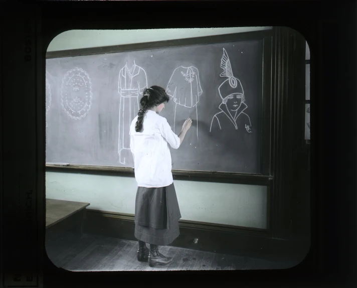 a  is writing on a chalk board