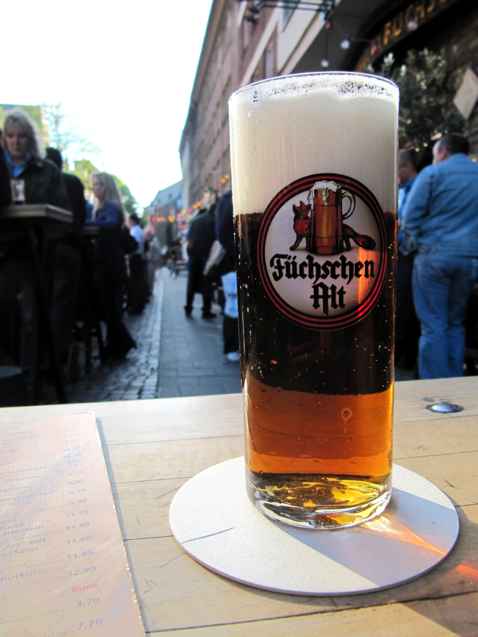 a glass of beer on the table in front of a pub