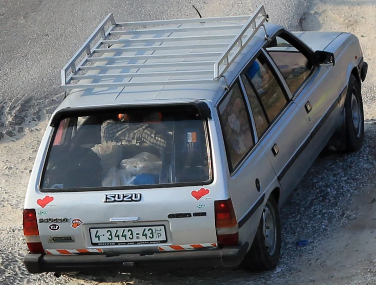 a white vehicle is driving down a dirt path