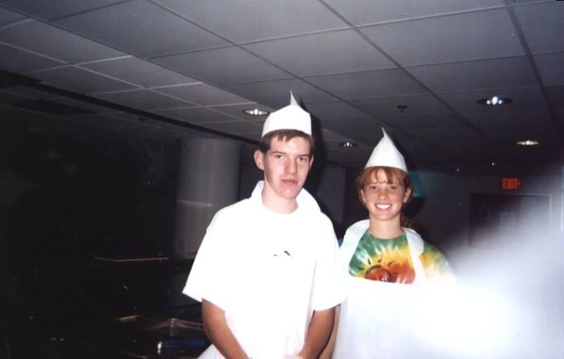 this man and woman are wearing party hats