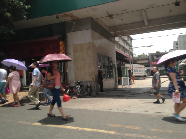 people crossing the street carrying umbrellas and wearing dresses