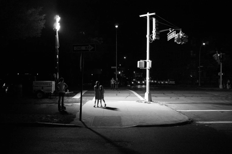 two people are crossing the street at night