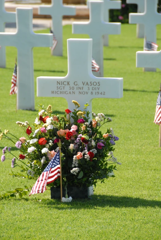 grave with american flags and flowers in it