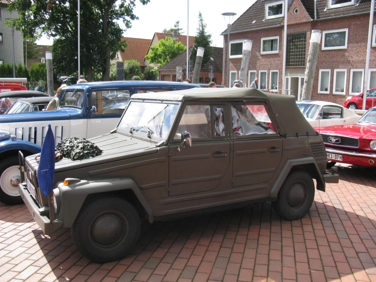 some older cars parked in a lot next to some houses