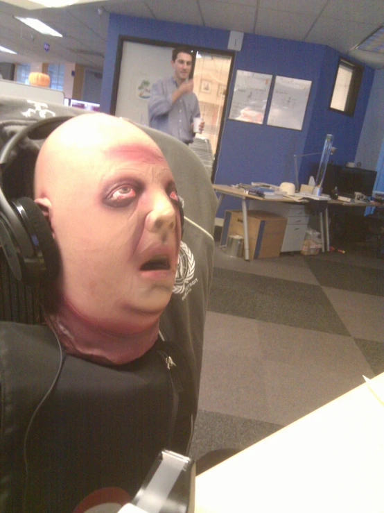 a bald man wearing a pair of headphones in an office