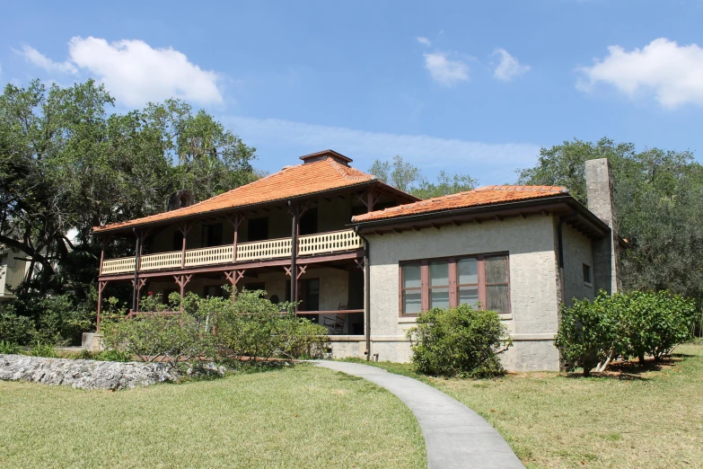 a large house with red tiled roof and balcony