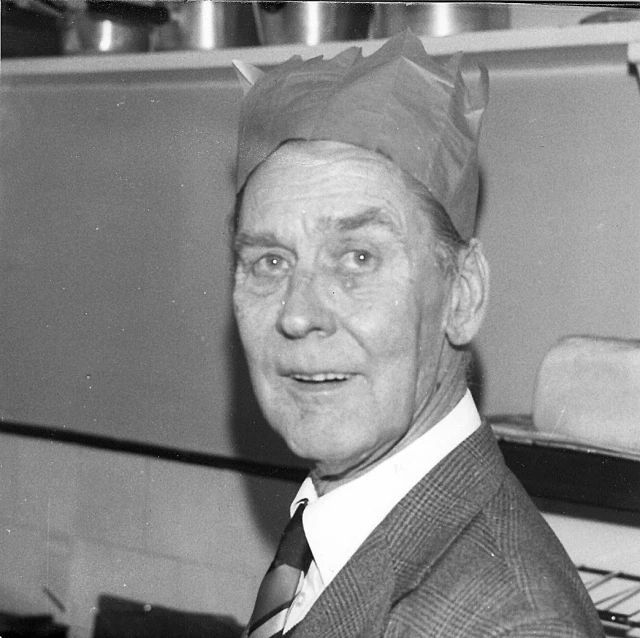 a man wearing a surgical cap is smiling for the camera
