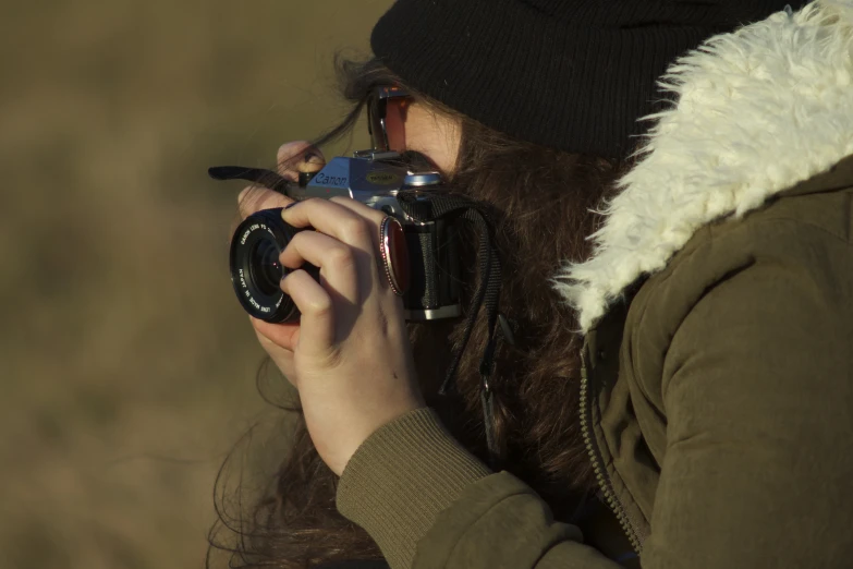 woman holding up a camera to take pos