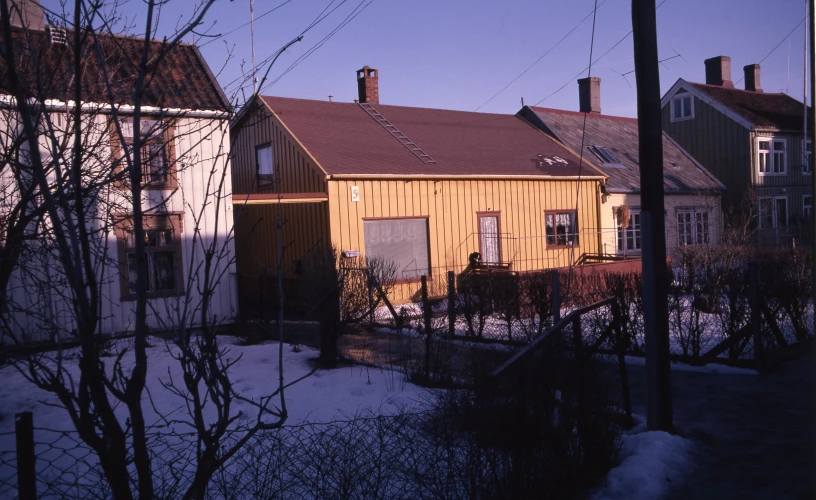 a yellow house and a few other buildings in a small town