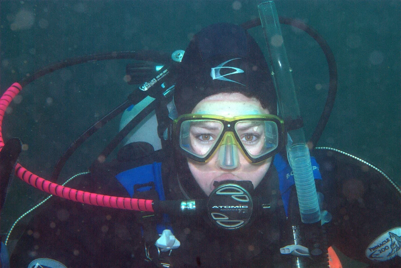 a man holding onto a boat while wearing a diving helmet and goggles