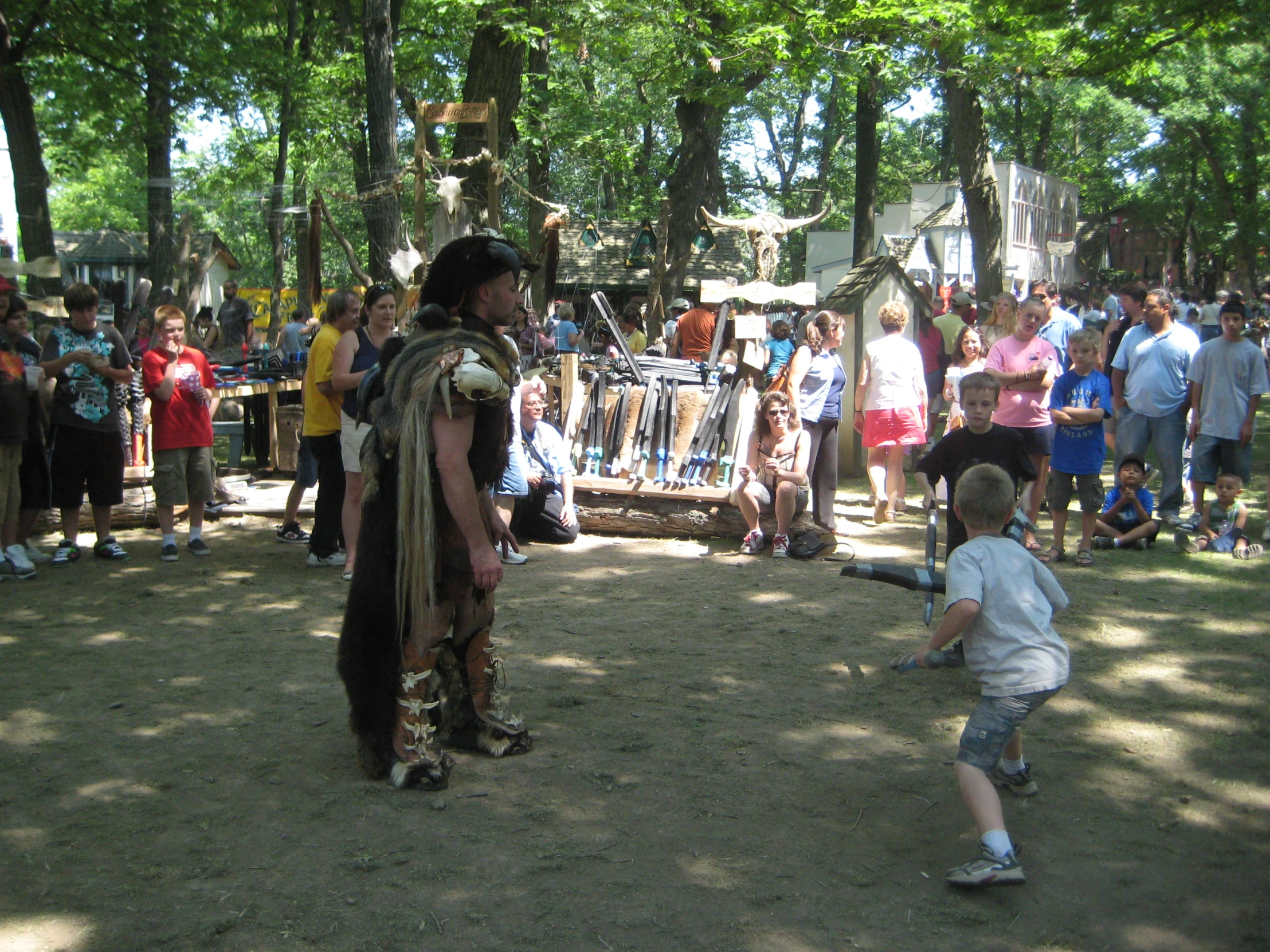 a young child plays with a large animal at the park