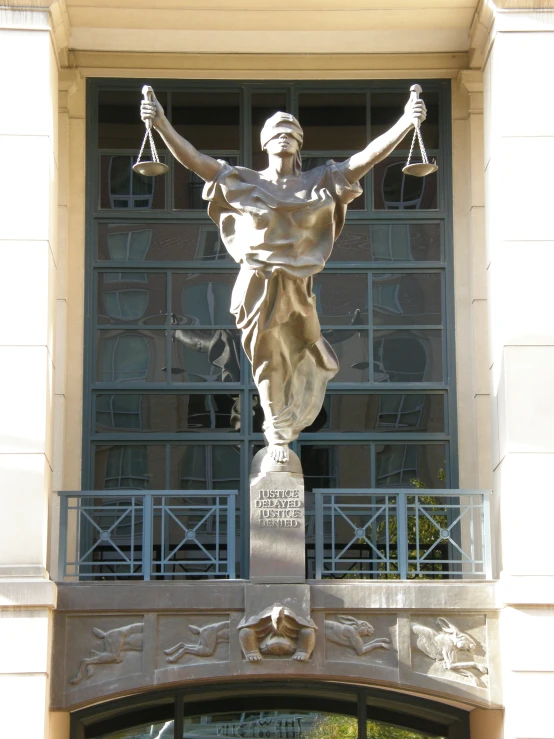a statue with an equal sign on it in front of a building