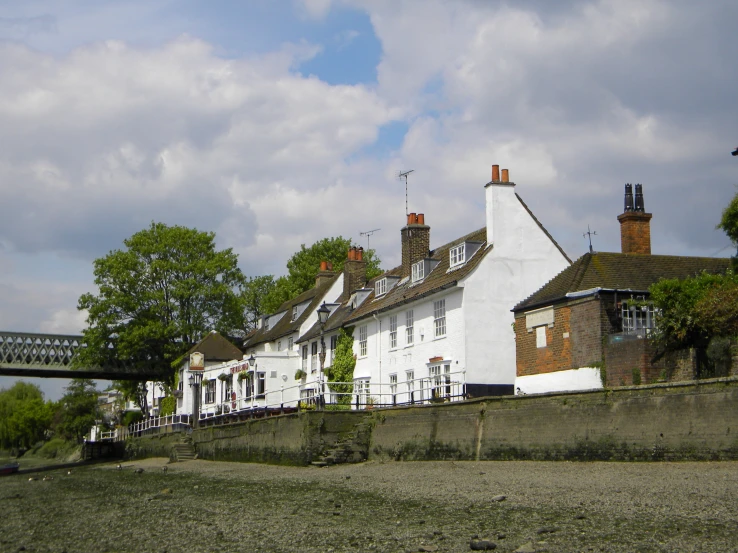 a white building with several chimneys sitting next to a bridge