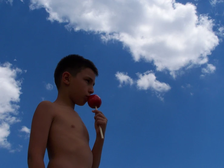 a  eating a piece of fruit against the sky