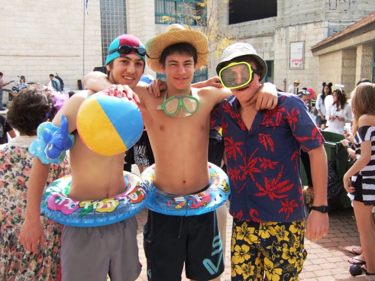 three young men are all wearing goggles while standing together in front of a crowd