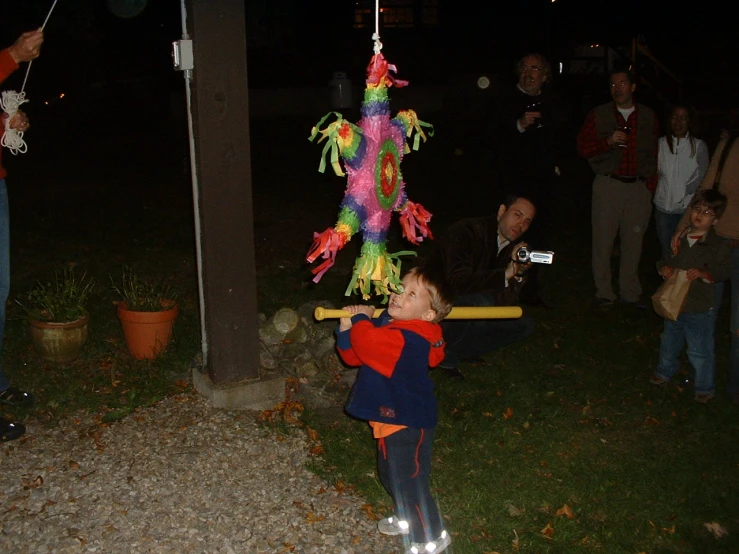 a small boy standing on top of a swing