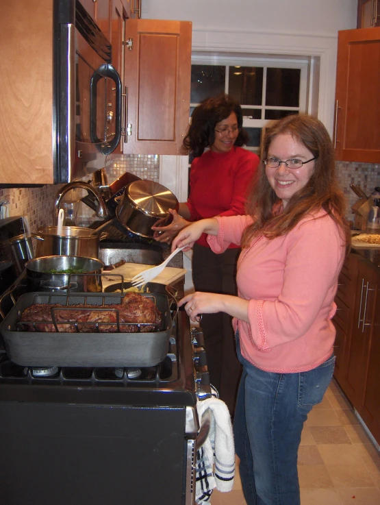 two women standing in a kitchen with their food