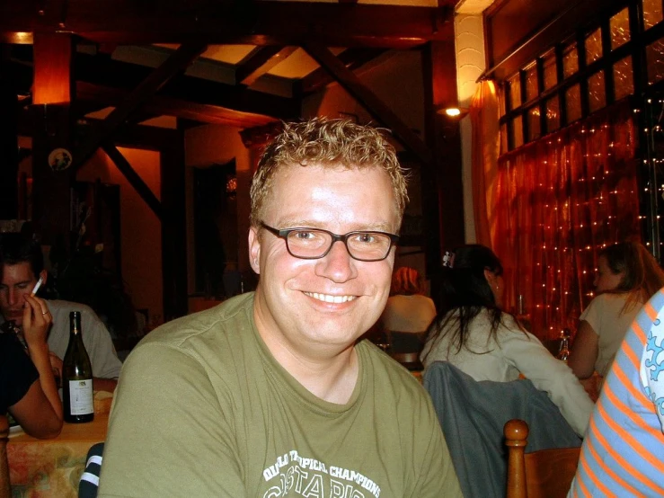 a smiling man in glasses in a restaurant