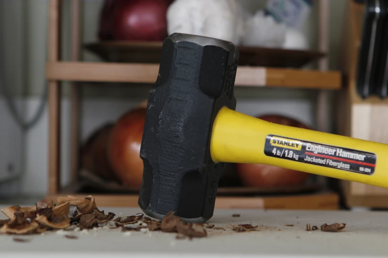 a hammer hitting a black and yellow piece of wood