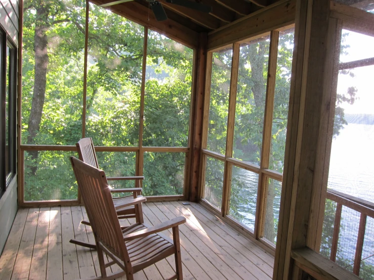 a wooden porch with a rocking chair on the front porch