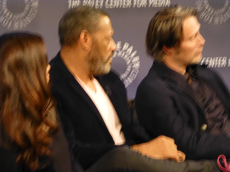 three people sitting together and some holding microphones