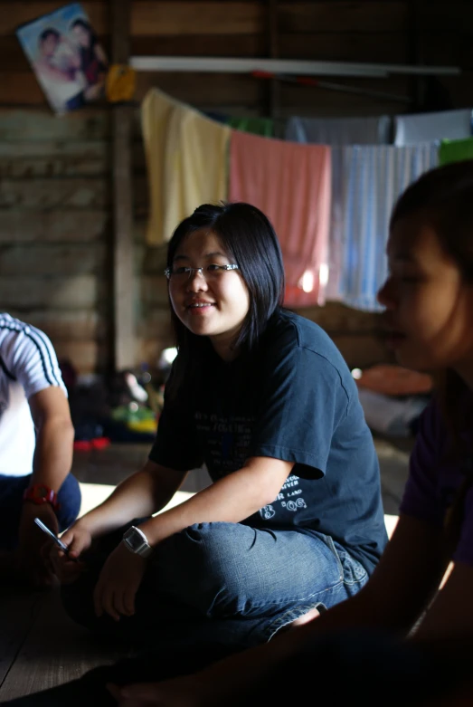 three people sitting around and watching soing on a table