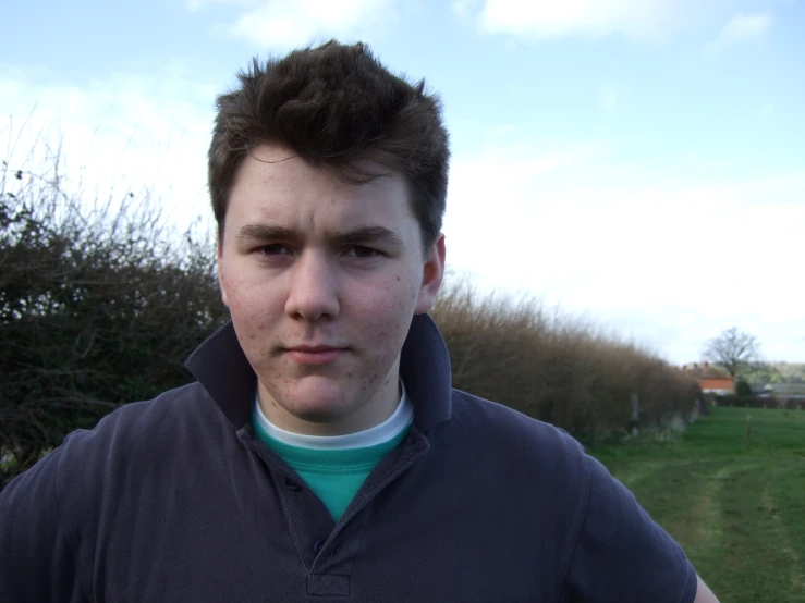 a young man is taking a selfie with trees and grass