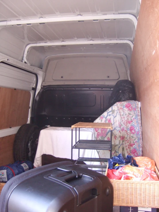 the back end of a vehicle with luggage on the bed