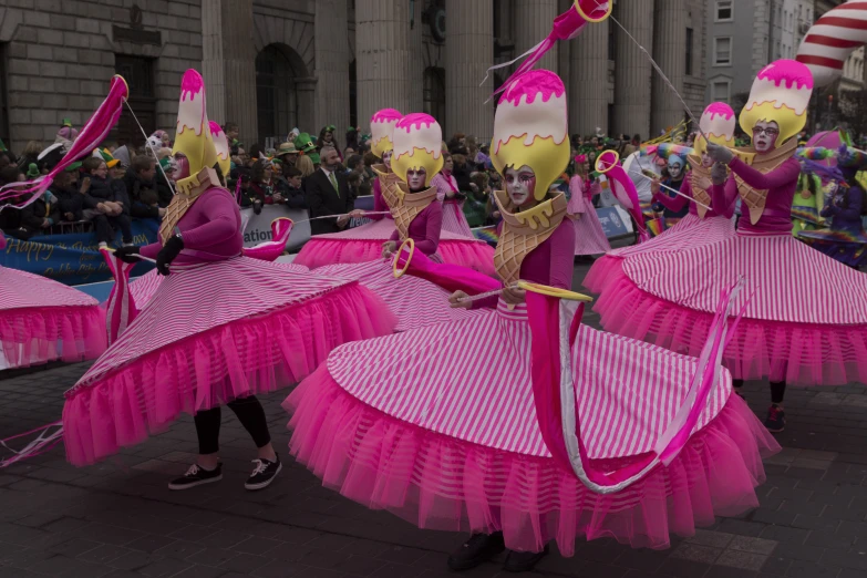 a group of performers dressed in costumes in the street