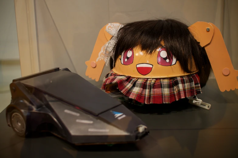 a desk with an odd looking stuffed toy next to a mouse