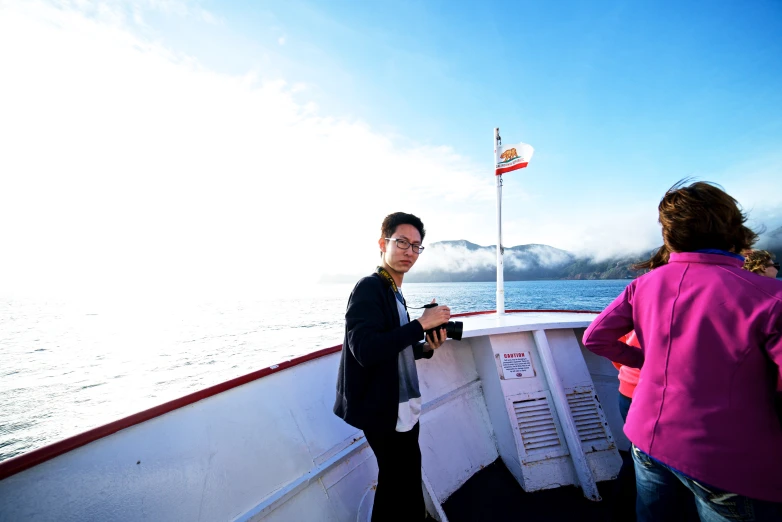 a woman on a boat is near a guy on the water