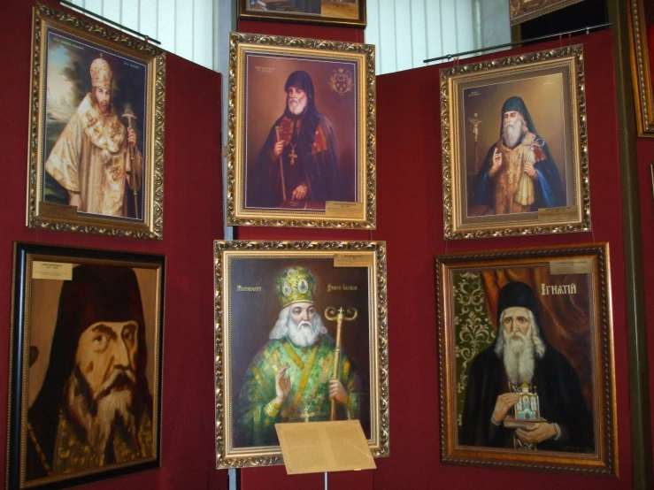 paintings on red walls depicting people with religious attire
