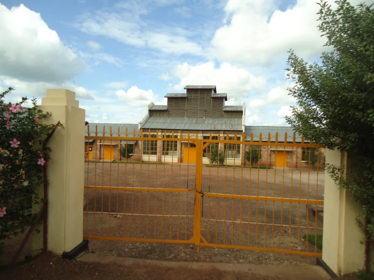 a yellow house with metal fence and gate