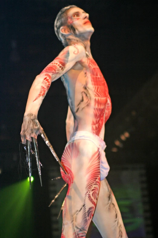 man with muscles and tattoos in a tight body costume