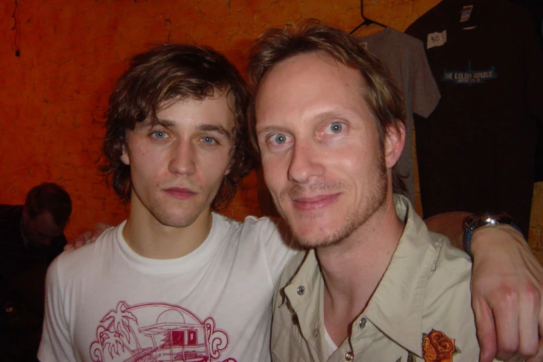 two young men one is smiling and the other is taking a selfie