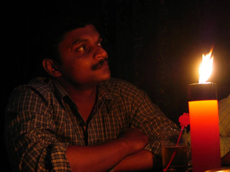 a man sitting at a table with a candle