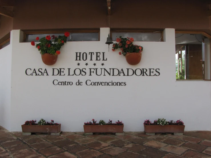 the el sign for an entrexicateur is covered with flower pots and flowers