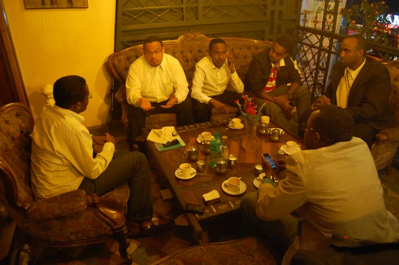 a group of men sitting around a wooden table