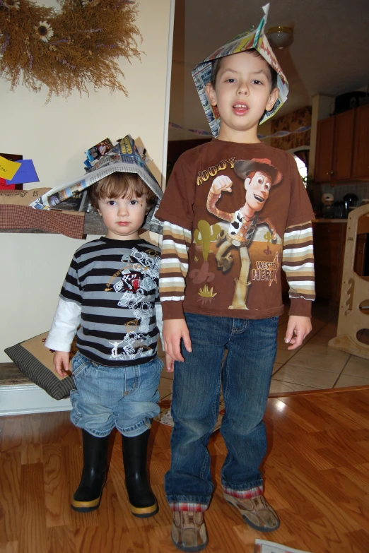 two children standing near each other in front of a fireplace