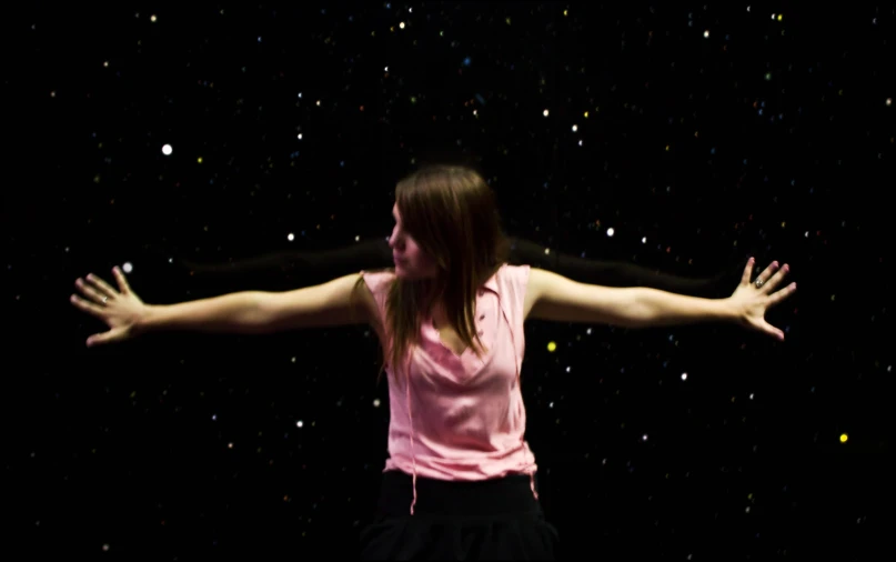 a woman wearing a pink tank top in the dark