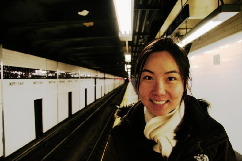 the girl is standing at the train station