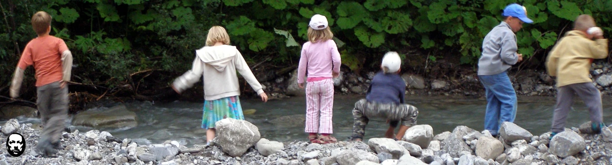 five people on rocks with trees in the background