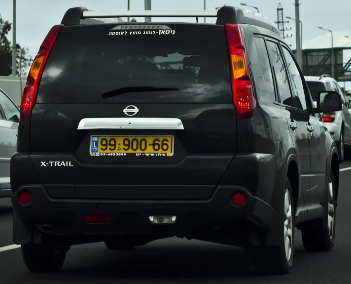 a gray minivan driving down a road near many other cars