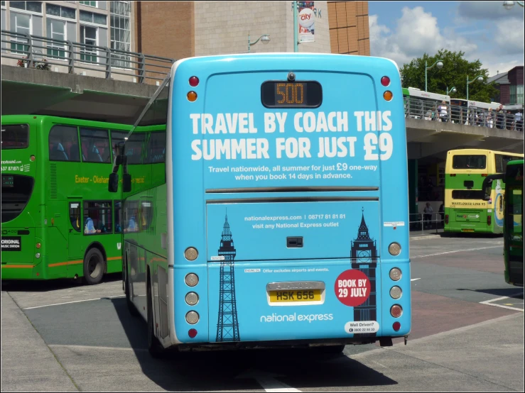 there is a blue bus that is parked in the street