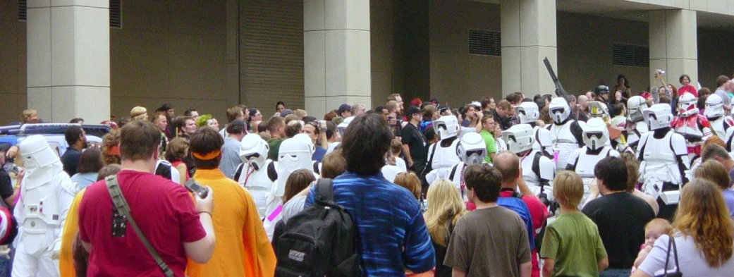 a crowd of people with white costumes and a few holding frisbees