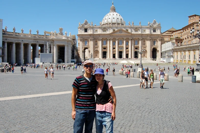 two people standing together in front of an elaborate building