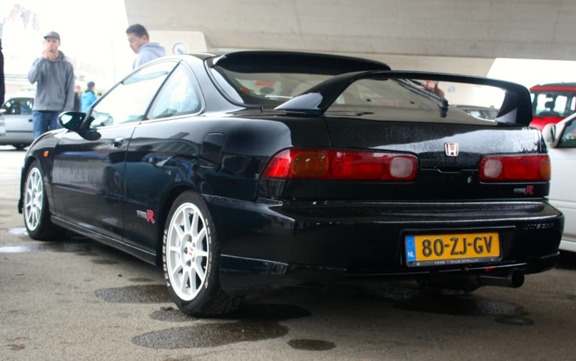 a black car parked next to a man in a black jacket