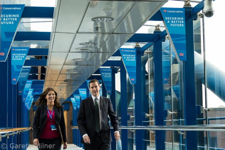 a man and a woman walking down a long walkway