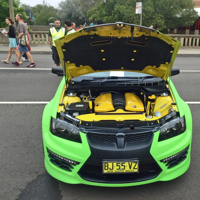 a lime green car with its hood open