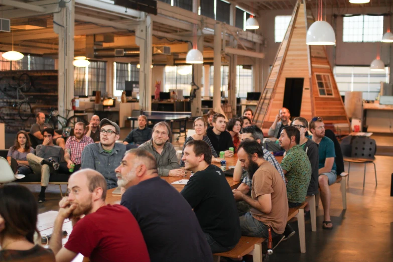 a room full of people sitting at small tables